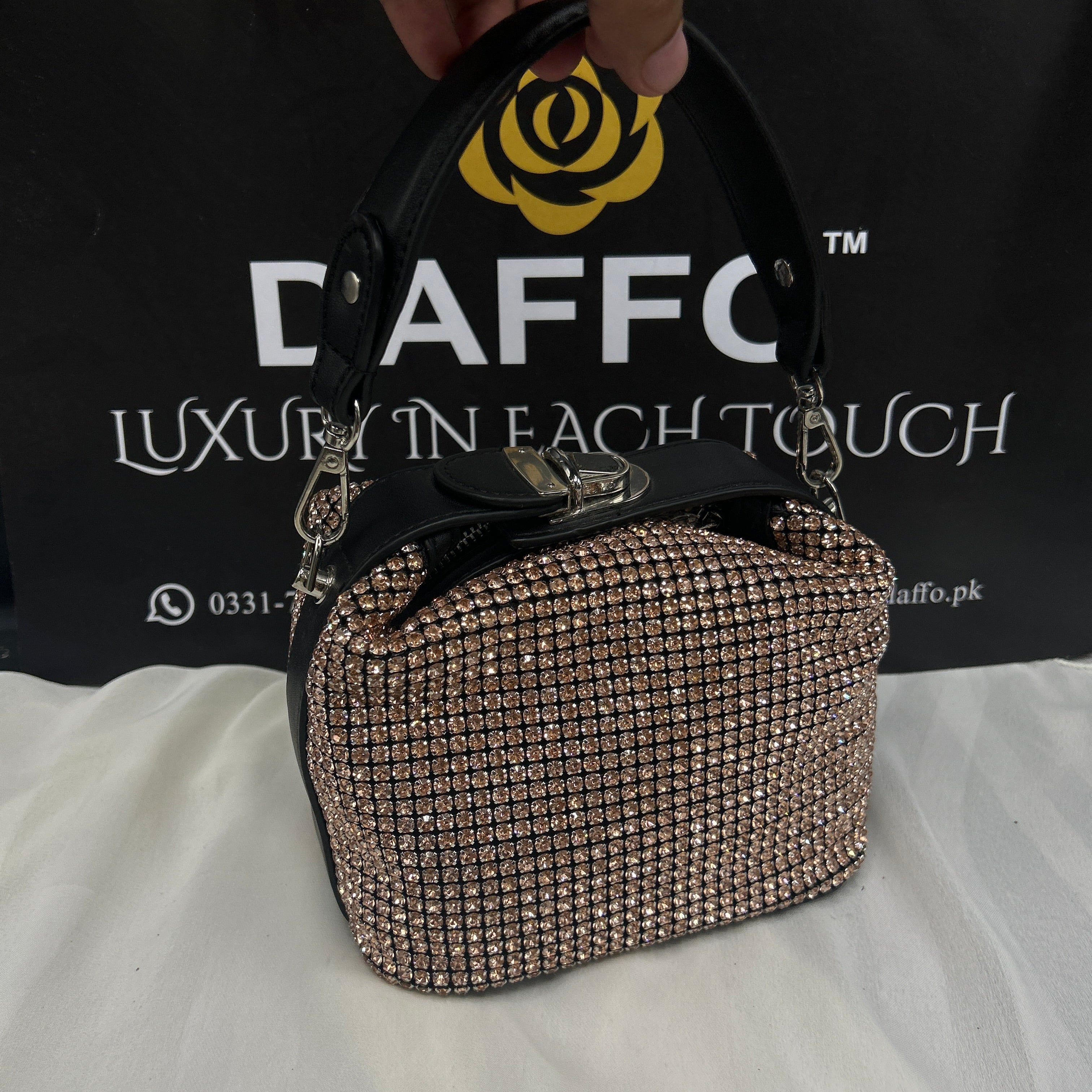 Hand holding a sparkly handbag 